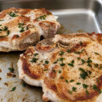 Seared herbed pork chops cooking on griddle